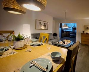 een eetkamer en een woonkamer met een tafel en stoelen bij Japanese Style MUJI Two-Bedroom Apt in Swansea
