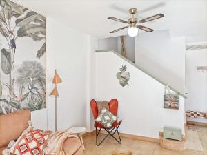 a living room with a ceiling fan and a chair at Casa Bakara Zahara beach in Zahara de los Atunes