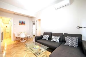a living room with a black couch and a table at MyHouseSpain - Superb apartment close to Madrid City Center in Madrid