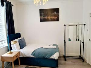 a small bedroom with a bed with a blue chair at Private House With FREE Parking in London