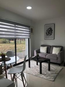 a living room with a couch and a table and chairs at Departamento Los Canelos, a metros de Avenida Las Industrias- Incluye, NETFLIX DirecTV aire acondicionado, Internet in Los Ángeles