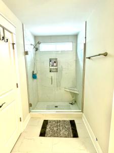a bathroom with a shower with a glass door at Pink Sand Hideaway in Hilton Head Island