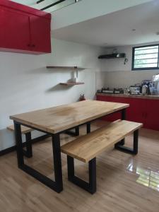 una mesa de madera y bancos en la cocina en Hans Jensen Residences, en Banlot