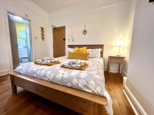 a bedroom with a bed with a tray of food on it at Driftwood Studio in Cromer