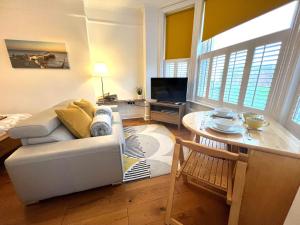 a living room with a couch and a table at Driftwood Studio in Cromer