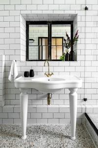 a white bathroom with a sink and a window at Vintage high design lofts -by Bookiz in Tel Aviv