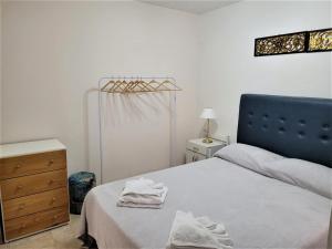 Un dormitorio con una cama y un tocador con toallas. en Departamento Mendoza Capital en Mendoza