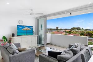 una sala de estar con 2 sofás y una ventana grande en Modern Contemporary Southport Apartment en Gold Coast