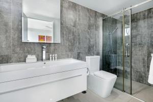 a bathroom with a sink and a toilet and a shower at Modern Contemporary Southport Apartment in Gold Coast