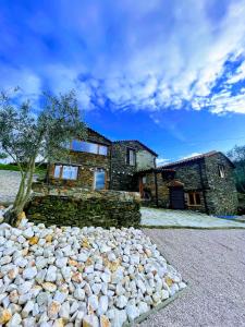 una casa de piedra con un montón de rocas delante de ella en Casa da Esculca, en Coja