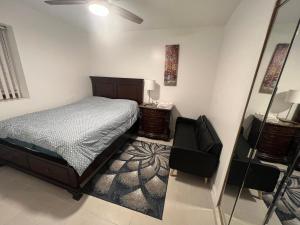ein Schlafzimmer mit einem Bett, einem Stuhl und einem Spiegel in der Unterkunft Lawn Residence in Brooklyn