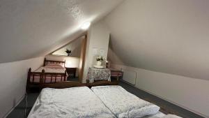 Cette chambre mansardée comprend deux lits et une table. dans l'établissement Haus Luise Monteure, à Delmenhorst