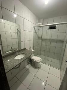 a bathroom with a toilet and a sink and a shower at Renata Palace Hotel in Criciúma