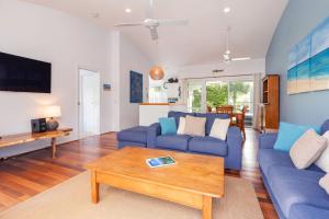 Sala de estar con sofás azules y mesa de centro en Waverider 2, en Boomerang Beach