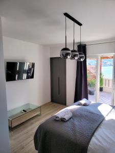 1 dormitorio con 1 cama con 2 toallas en Kupinica Apartment, en Vinišće
