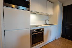 una cucina con mobili bianchi, un lavello e una stufa di AC Tourisme Le Touquet - Appartements avec piscine et tennis a Le Touquet-Paris-Plage Altre 96 foto