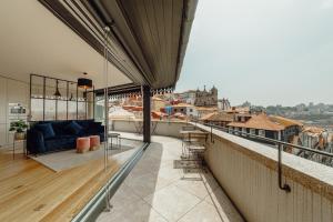 einen Balkon mit einem Sofa und Stadtblick in der Unterkunft Downtown Penthouse With River View by Vacationy in Porto