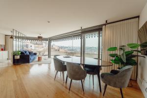 ein Esszimmer mit einem Tisch und Stühlen in der Unterkunft Downtown Penthouse With River View by Vacationy in Porto