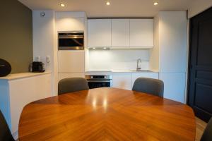 una cucina con tavolo e sedie in legno di AC Tourisme Le Touquet - Appartements avec piscine et tennis a Le Touquet-Paris-Plage