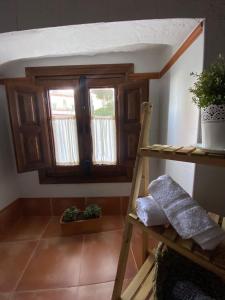 a room with a ladder and windows in a room at Acogedora casa rural en Olvera ,La Morada in Olvera