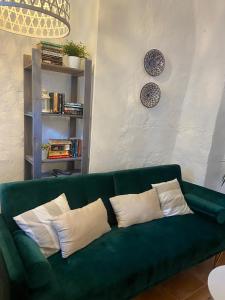 a green couch with pillows in a living room at Acogedora casa rural en Olvera ,La Morada in Olvera
