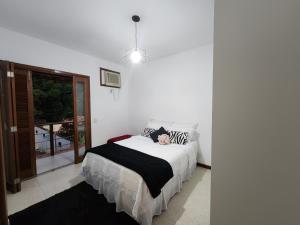 a bedroom with a bed with a person laying on it at CASA ALECRIM PISCINA PRIVATIVA COM Dec MOVEL Ideal Crianças in Niterói