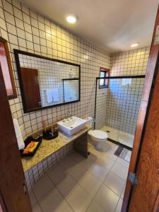 ein Badezimmer mit einem Waschbecken, einem WC und einem Spiegel in der Unterkunft CASA ALECRIM PISCINA PRIVATIVA COM Dec MOVEL Ideal Crianças in Niterói