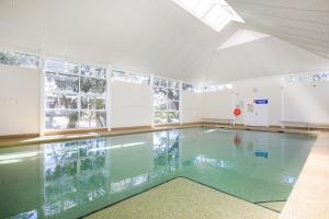 an empty swimming pool with a glass floor at Havenwood - Pet Friendly - Spa & Community Pool in Callala Beach