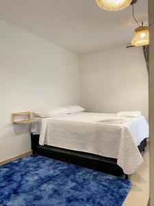 1 dormitorio con 2 camas y alfombra azul en Selvática Alojamiento Eco en Medellín