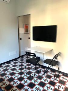a room with a table and two chairs and a tv at Design studio Margherita in Cinisello Balsamo
