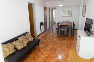 sala de estar con sofá negro y mesa en Cómodo y Agradable Departamento Céntrico en Rosario