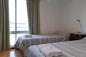 um quarto de hotel com duas camas e uma janela em Cómodo y Agradable Departamento Céntrico em Rosário