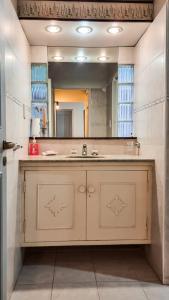 a bathroom with a sink and a large mirror at Como en casa in Chacras de Coria