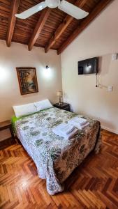 1 dormitorio con 1 cama y ventilador de techo en Como en casa en Chacras de Coria