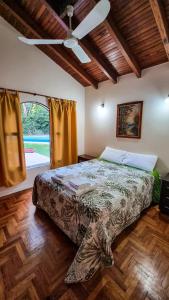 a bedroom with a bed and a ceiling fan at Como en casa in Chacras de Coria