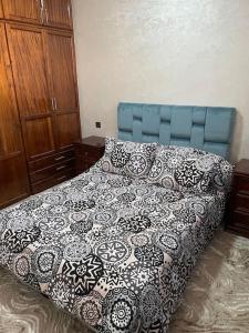 een slaapkamer met een bed met een blauw hoofdeinde en kussens bij Villa Charaf in Agadir