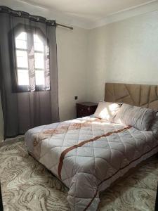 een bed in een slaapkamer met een raam en een bed sidx sidx sidx bij Villa Charaf in Agadir