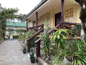 una casa con una valla de madera y algunas plantas en The White Pine at No 7 Pucay Village en Baguio