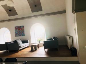 un soggiorno con 2 divani e 2 finestre di Afan Forest BunkHouse-Fantastic 6 Rooms -Sleeps 23 a Glyncorrwg