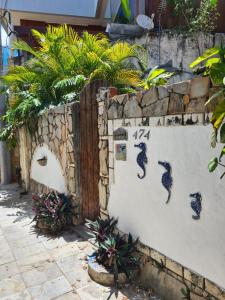 een stenen muur met tekeningen van zeepaardjes erop bij Casa de Dan in Pipa