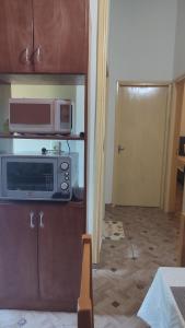 a kitchen with a microwave and a door to a room at Casa independiente amoblada en Capiata in Capiatá