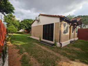 een klein huis met een tuin ervoor bij Casa independiente amoblada en Capiata in Capiatá
