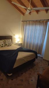 1 dormitorio con 1 cama grande y cortina azul en Casa independiente amoblada en Capiata, en Capiatá