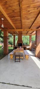 patio ze stołem i ławkami oraz drewnianym sufitem w obiekcie Casa de Campo- Terra Viva w mieście San Salvador de Jujuy