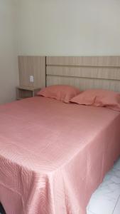 - un lit rose avec des draps et des oreillers roses dans l'établissement CALDAS NOVAS - GO - Apartamento Parque das Aguas Quentes bloco 1 - em frente Clube Privê, à Caldas Novas