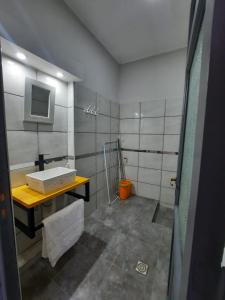 baño con lavabo y TV en la pared en Departamento Los Nonos en San Rafael