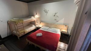 Hostel Boutique Merced 88 في سانتياغو: غرفة صغيرة بسريرين وسرير احمر