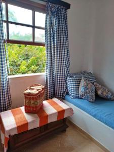 asiento junto a la ventana en una habitación con ventana en Casa Peró, en Cabo Frío