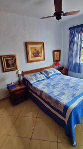 1 dormitorio con 1 cama y ventilador de techo en Casa Peró, en Cabo Frío
