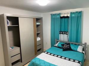 a small bedroom with a bed and blue curtains at AJ resort in Fontein